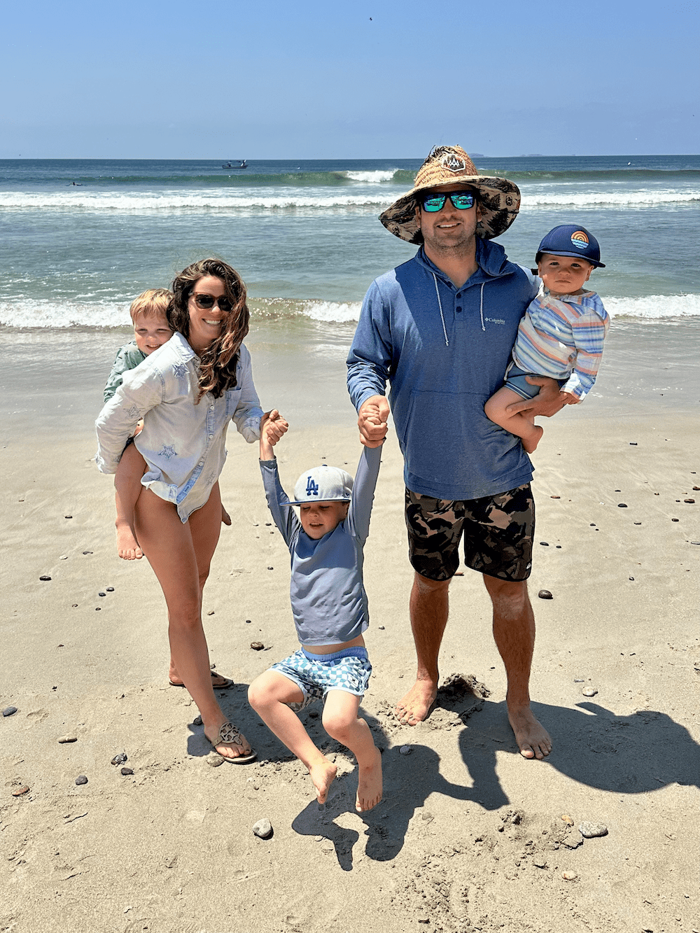 Morgan's family standing on the beach as waves roll in behind them.