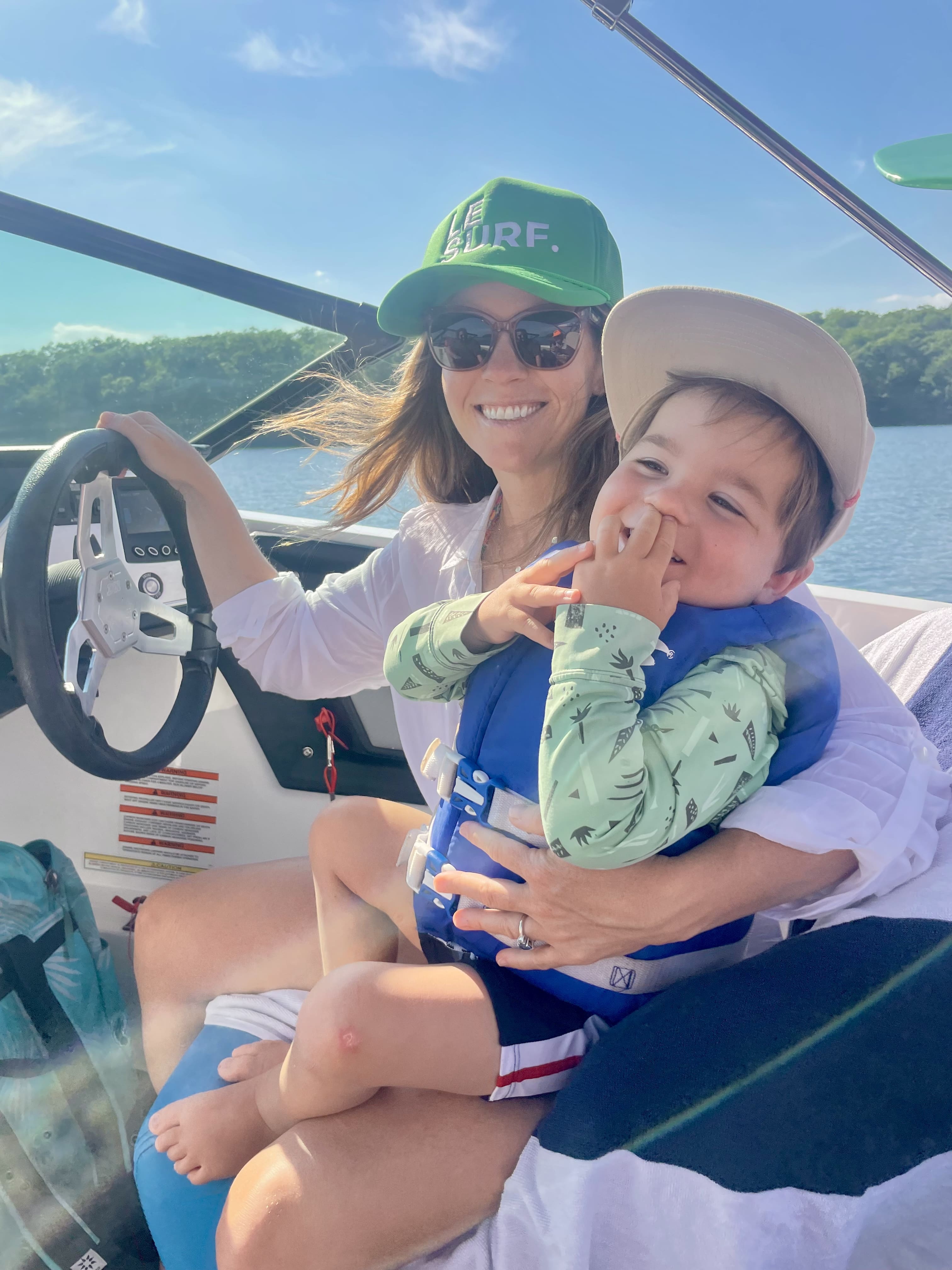 Morgan and a child on a boat with a scenic background.